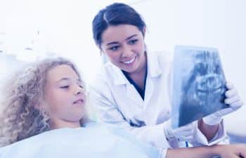 Dentist showing an x-ray to the child patient