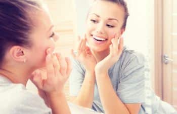 smiling woman looking at herself in the mirror